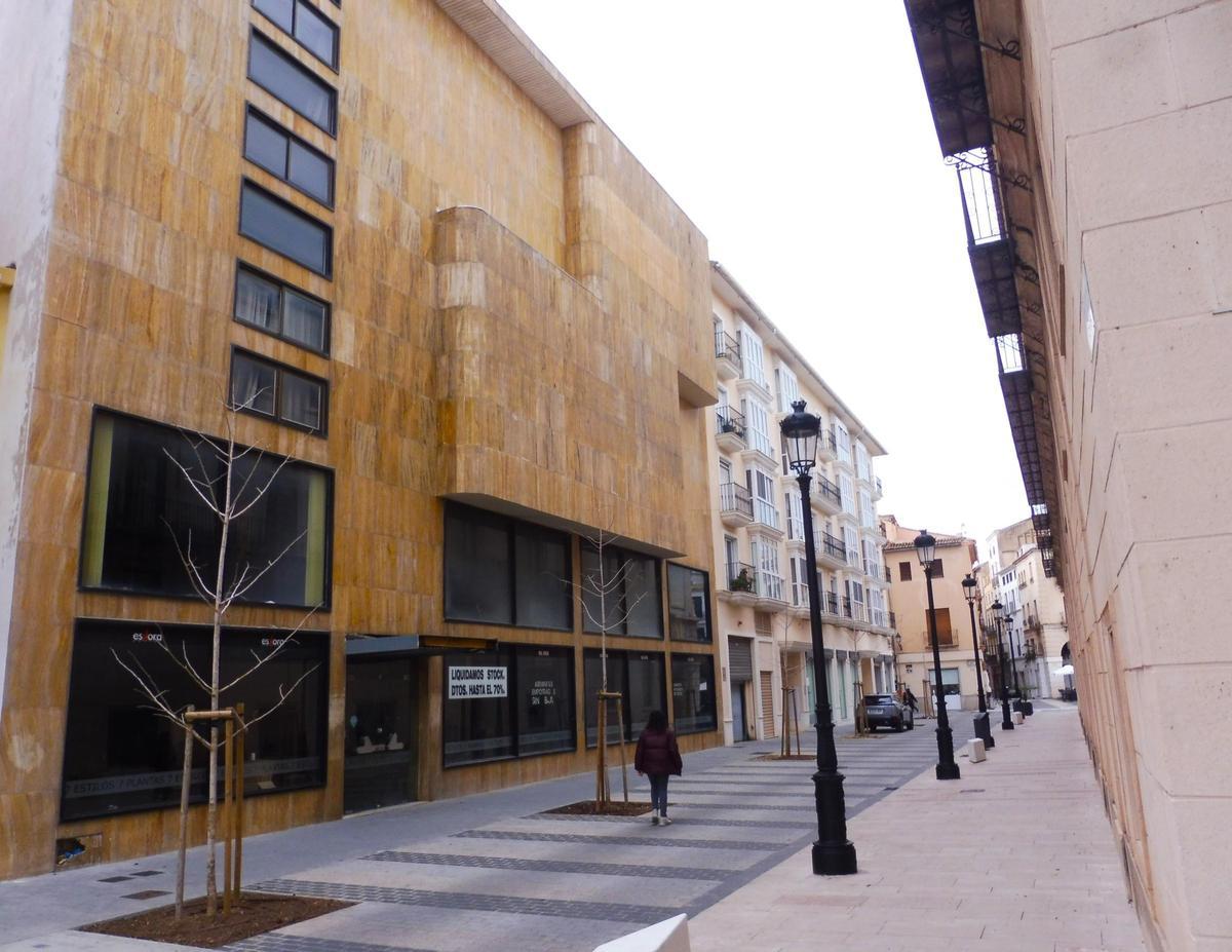 Vista del edificio, a la izquierda con la fachada marrón y de cinco alturas, en la calle dels Arcs, en Gandia.