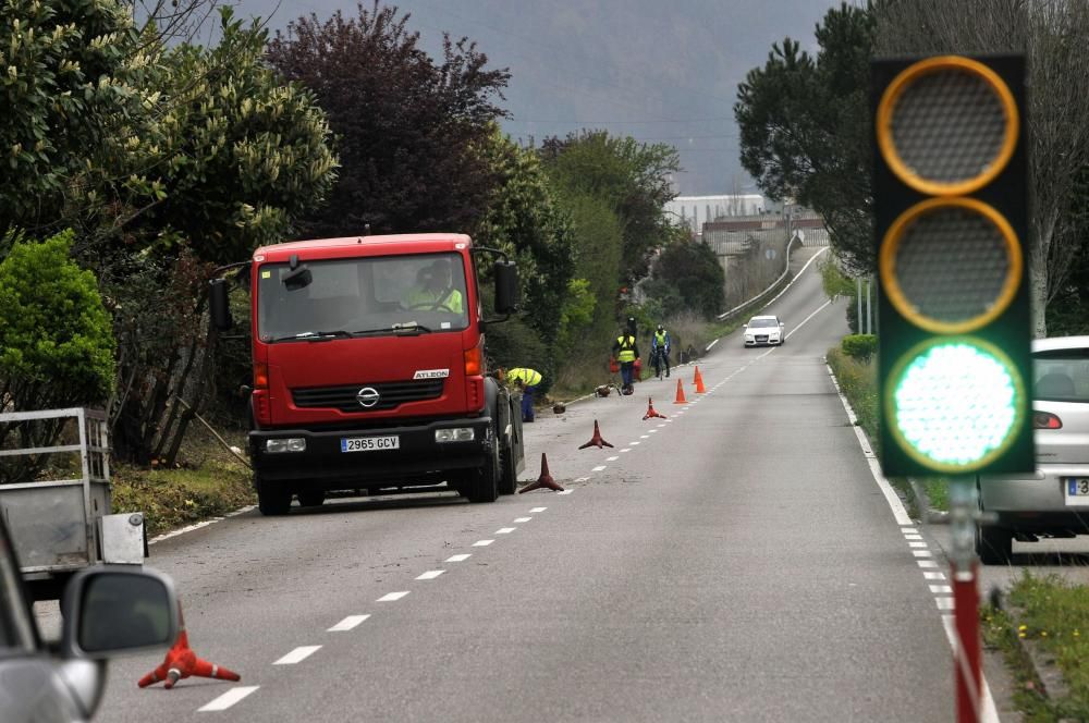 Trabajadores municipales en labores de desbroce en el paseo fluvial de Mieres con paso alternativo de vehículos