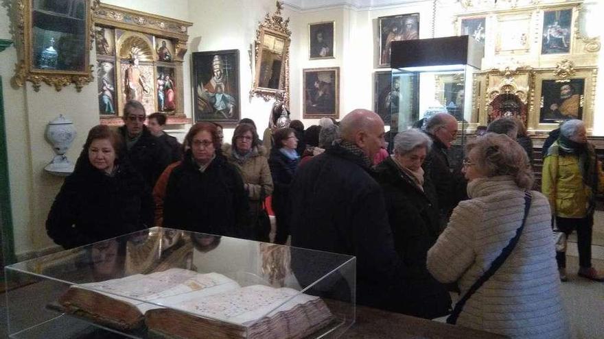 Un grupo de visitantes admira los fondos expuestos en la sacristía de la Colegiata de Toro.