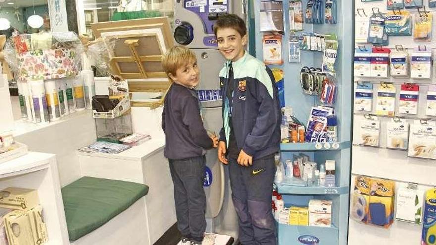 Niños pesándose en una farmacia de Pontevedra. // Santos Álvarez