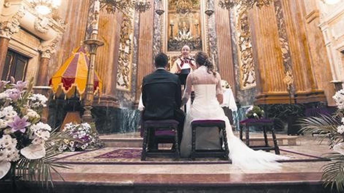 Una pareja escucha el sermón del párroco durante su enlace matrimonial.