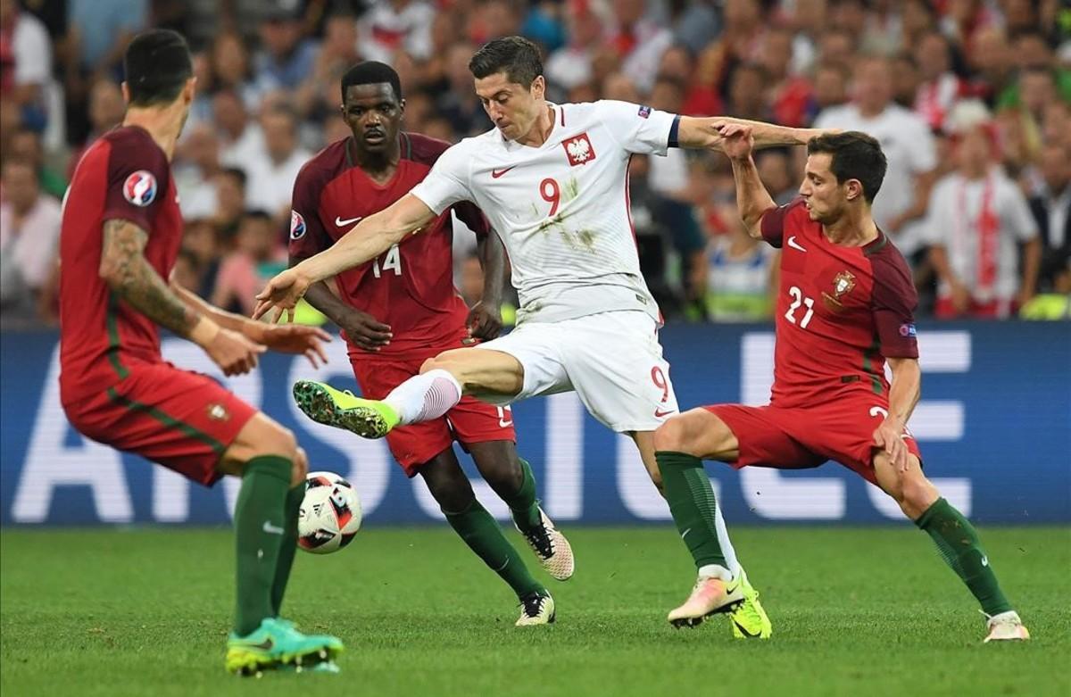 El polaco Lewandowski lucha el balón con los portugueses Carvalho y Soares.