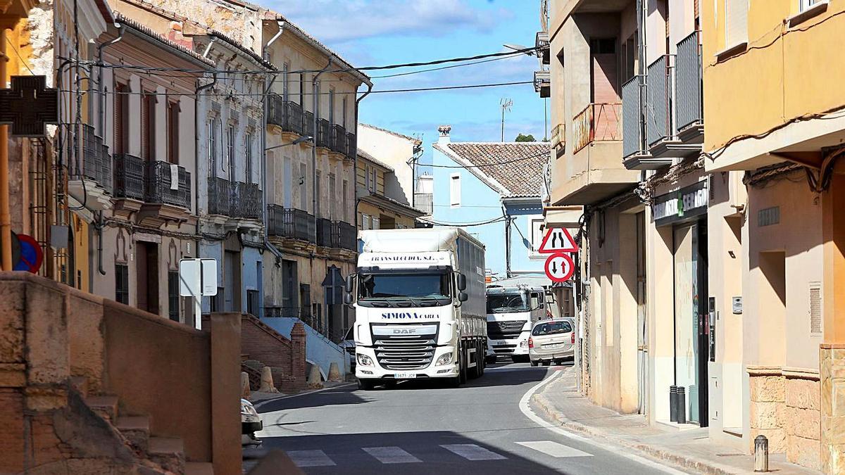 Un camión atraviesa el casco urbano de Pedralba, que tiene proyectada una ronda por el exterior. | PACO CALABUIG