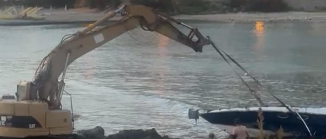 Vídeo: Desguazan una barca que llevaba cinco días varada en la playa de Cala Llonga