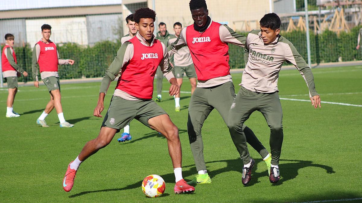 César Bonafé, Alassane Diatta y Facundo Viveros, pugnan un balón en un entrenamiento.