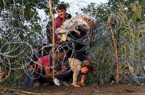 Así pasan la alambrada de Hungría los refugiados