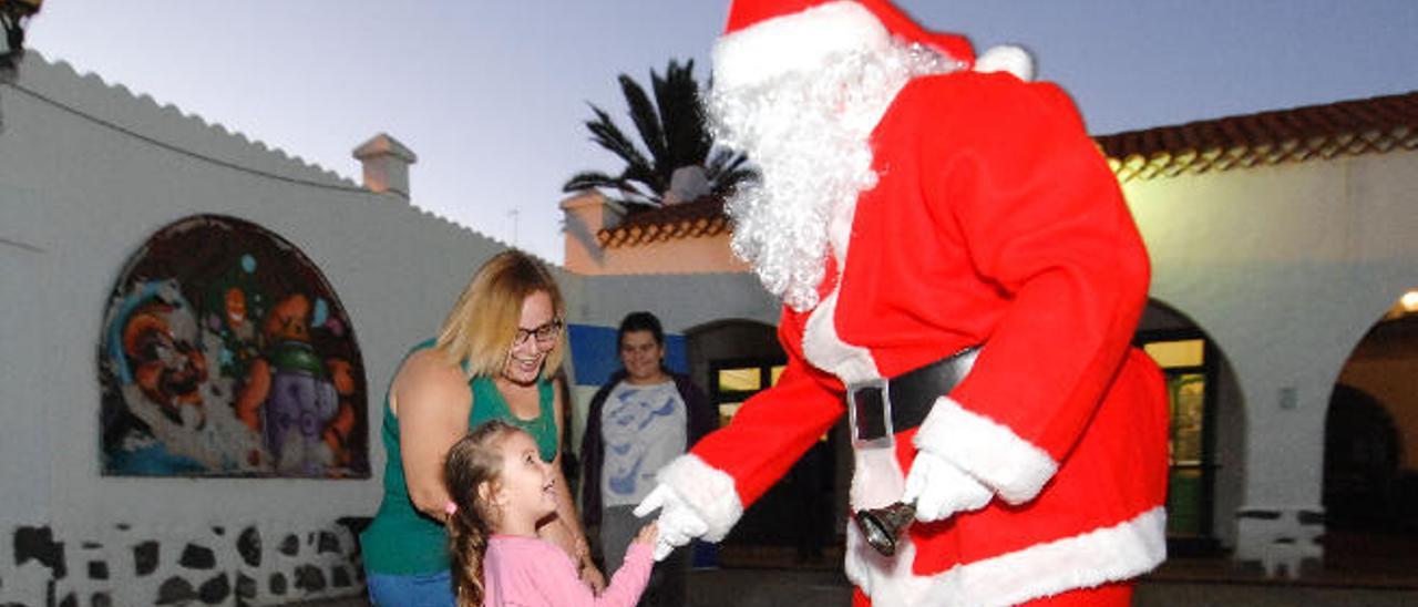 Una de las niñas saluda a Papá Noel durante el acto.