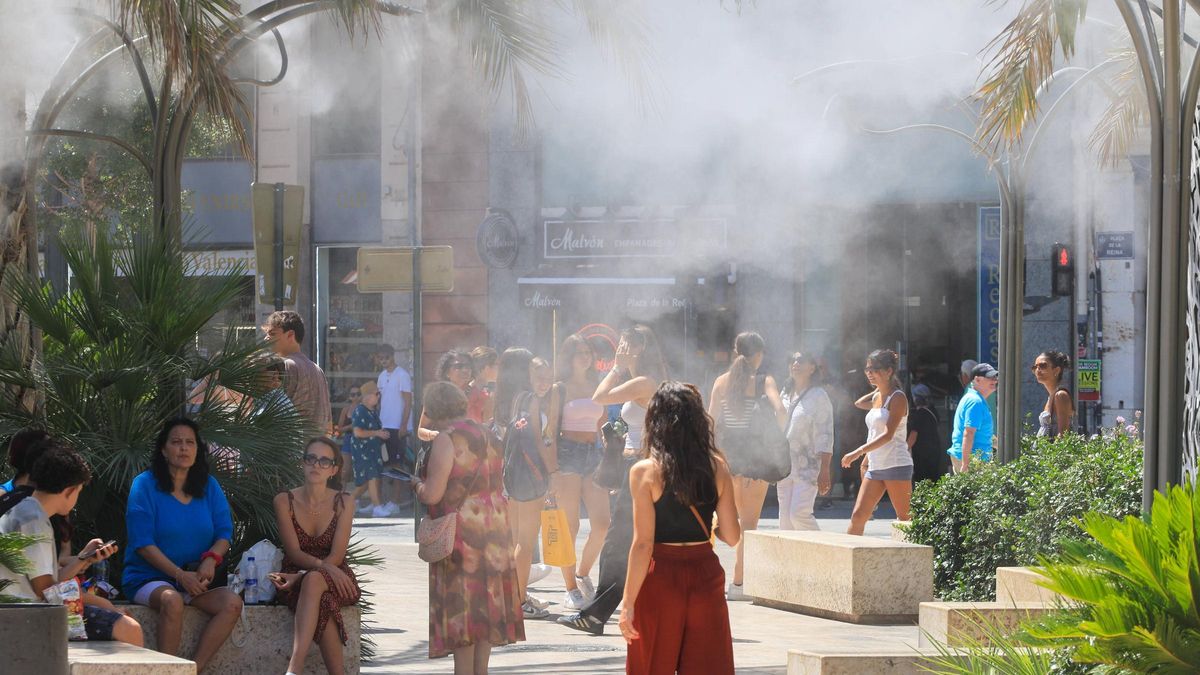 Personas resguardándose del calor el domingo en el centro de València.