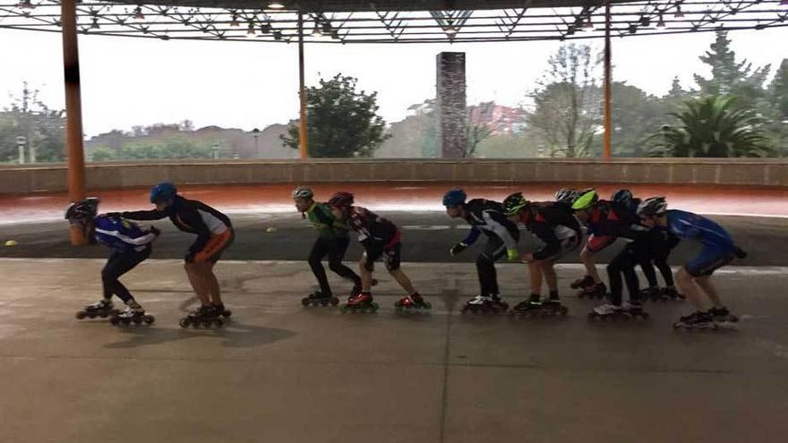 Patinadores ejercitándose en el interior del patinódromo al estar la pista encharcada.