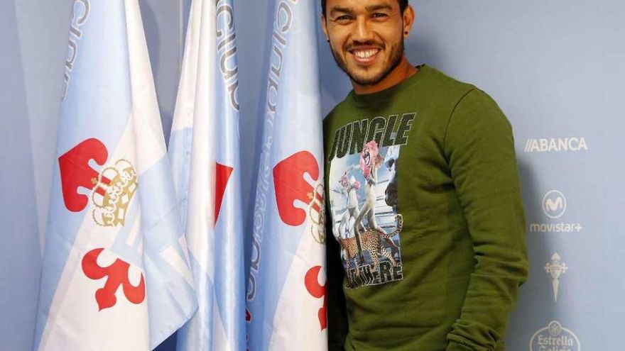 Gustavo Cabral posa junto a banderas del Celta en la sala de prensa de Balaídos. // Marta G. Brea