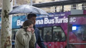 Una pareja se resguarda de la lluvia este marzo en Barcelona