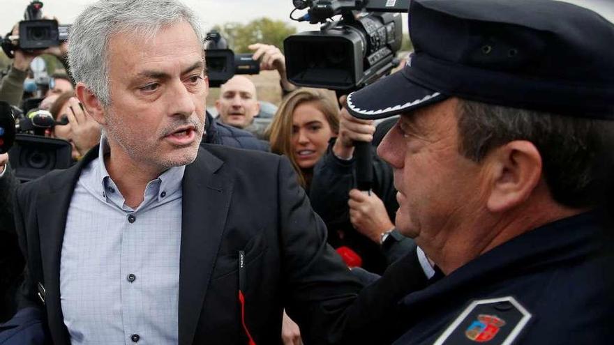 Mourinho pasa junto a un policía en su llegada al juzgado. // Javier Barbancho