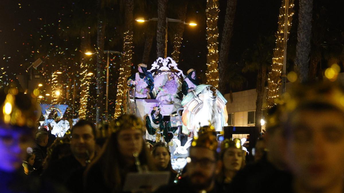 Un grupo de personas acmpaña la carroza en la cabalgata de reyes.