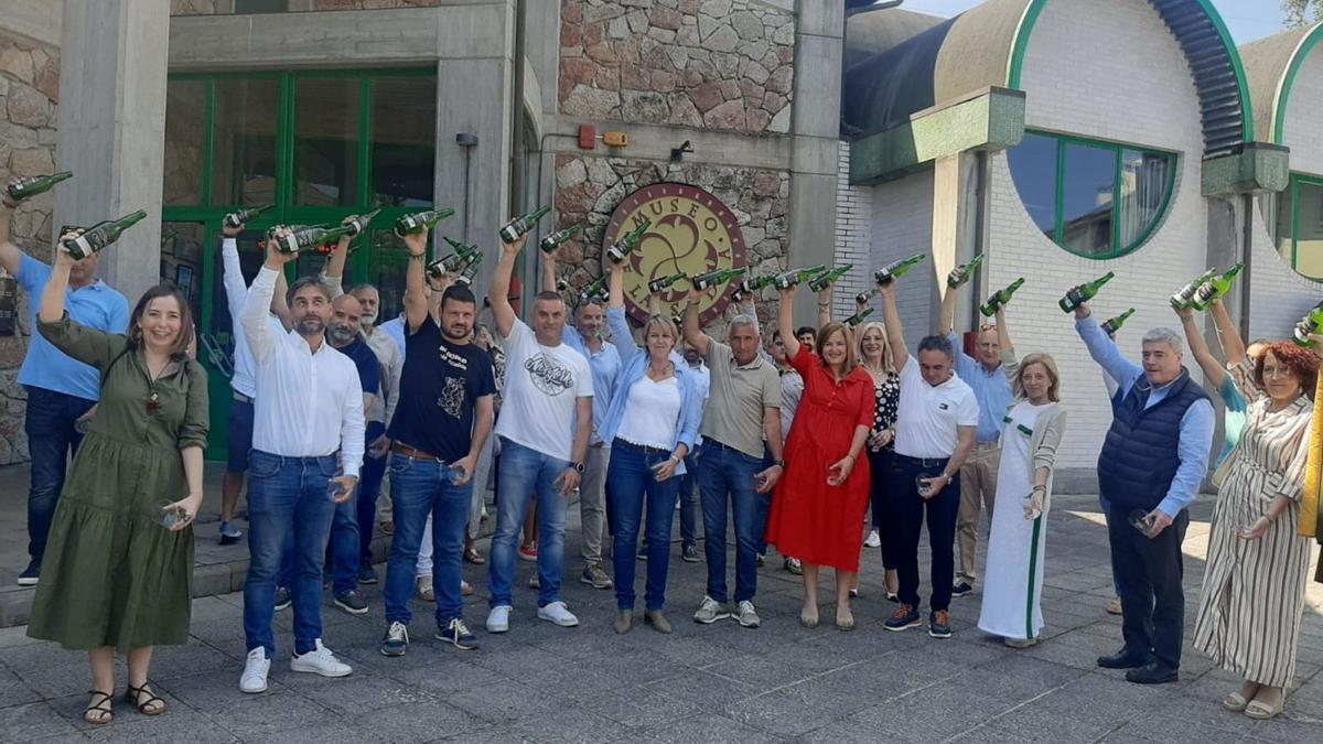 Por la izquierda, en primer término, Rocío Vega, Gerardo Fabián, Aitor García, Mino García, Sandra Vigón, Marcelino Martínez, Begoña López, Juan Cañal, Amparo Antuña, Víctor Ramos y Cecilia Pérez, en el escanciado simultáneo ante el Museo de la Sidra de Nava. | L. Palacios