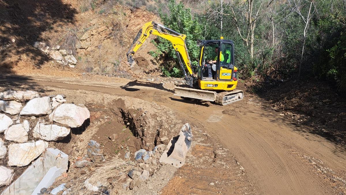 Una excavadora habilita un carril para el acceso a diseminados de Málaga.