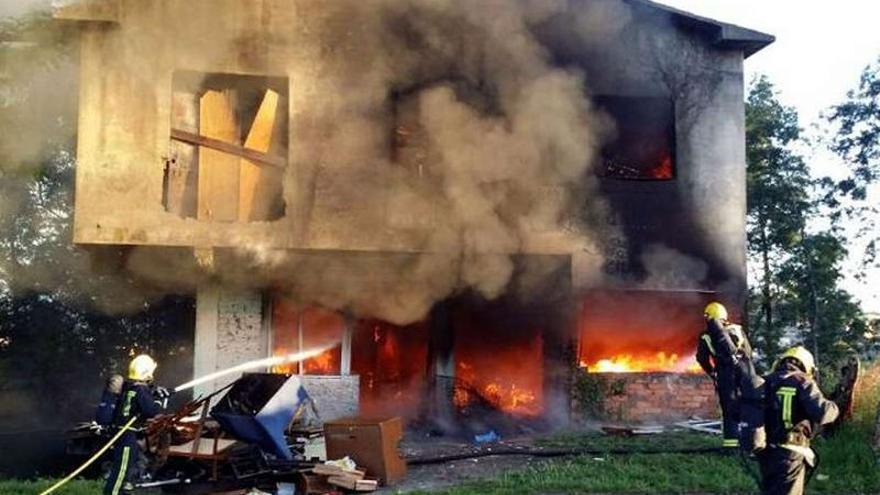 Los bomberos, trabajando en la extinción de la vivienda abandonada de Monte Porreiro.