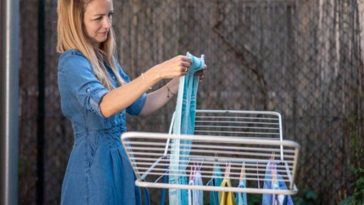 Una mujer colgando ropa en un tendedero