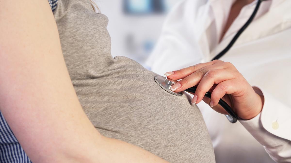 Un médico examina a una paciente embarazada para inducirle el parto