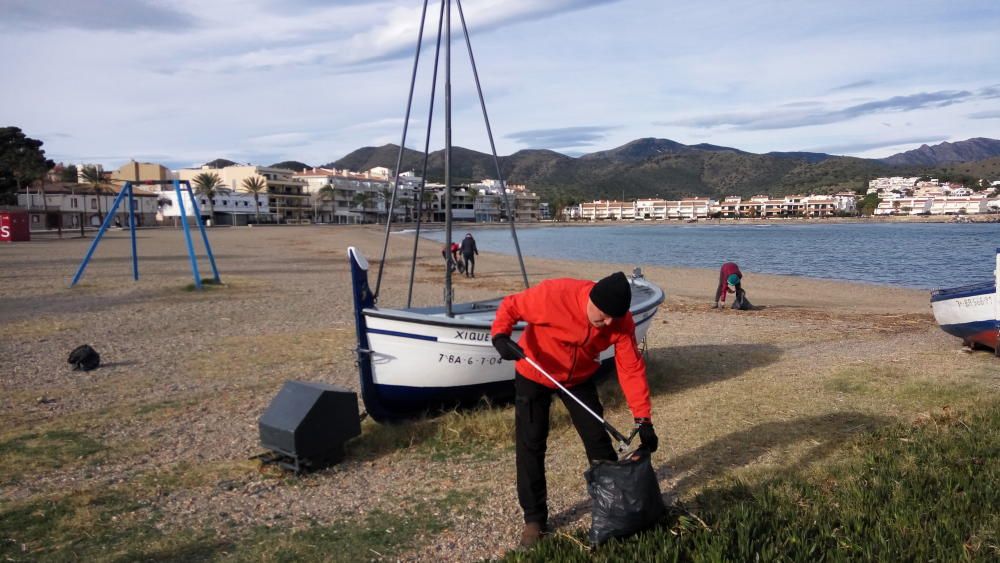 Voluntaris netegen la brossa a la platja de Llançà