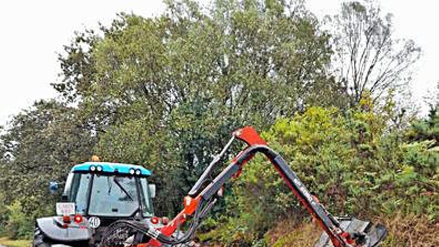 Un tractor realiza desbroces.