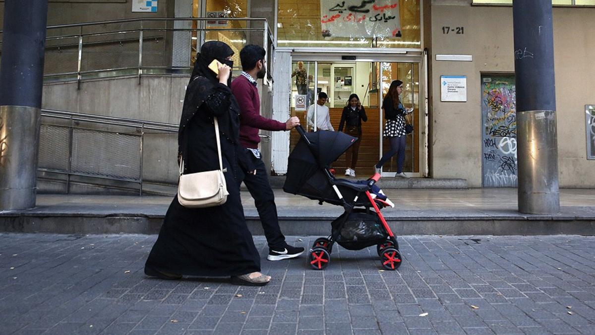 Una joven familia inmigrante pasea por el centro de Barcelona