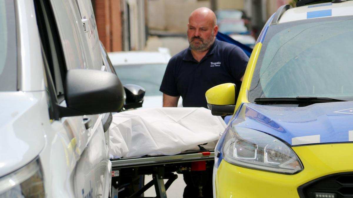 Personal de la funeraria, trasladando el cuerpo de la víctima.