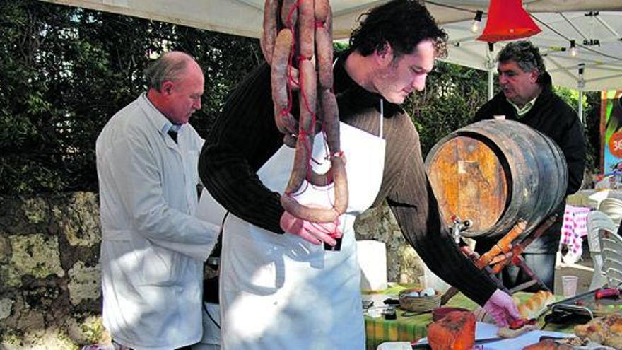 Un charcutero de la localidad despachando sobrassada frita a un visitante.