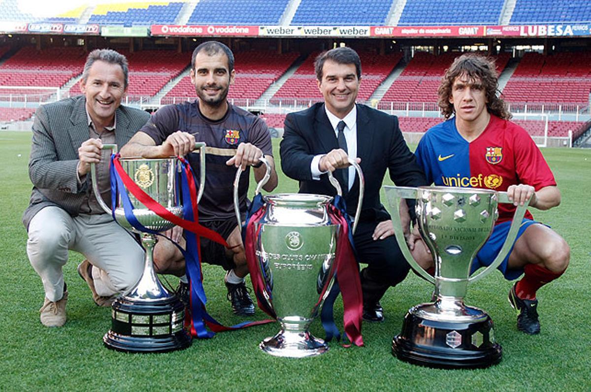 Txiki Begiristain, Pep Guardiola, Joan Laporta i Carles Puyol ensenyant els tres trofeus de Copa, Lliga i Champions al Camp Nou.
