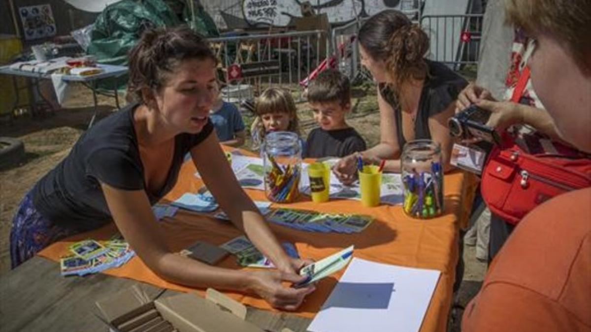 Intercambio 8 Miembros de la cooperativa de urbanismo Raons Públiques muestran los cromos a los niños.