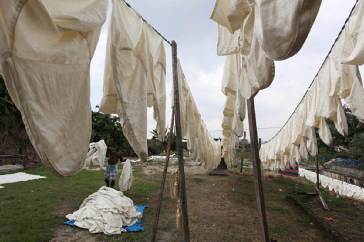 Un home recull la roba estesa abans que comenci a ploure en un suburbi de Kuala Lumpur (Malàisia).