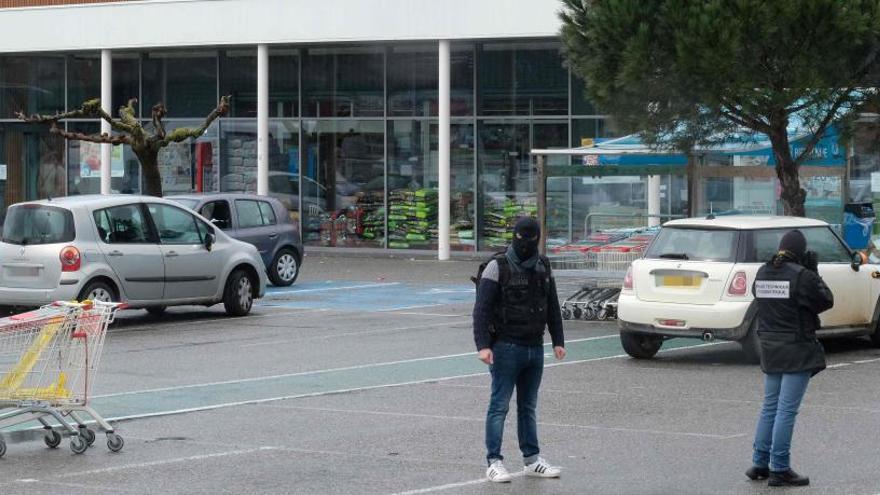 Policías frente al supermercado atacado.