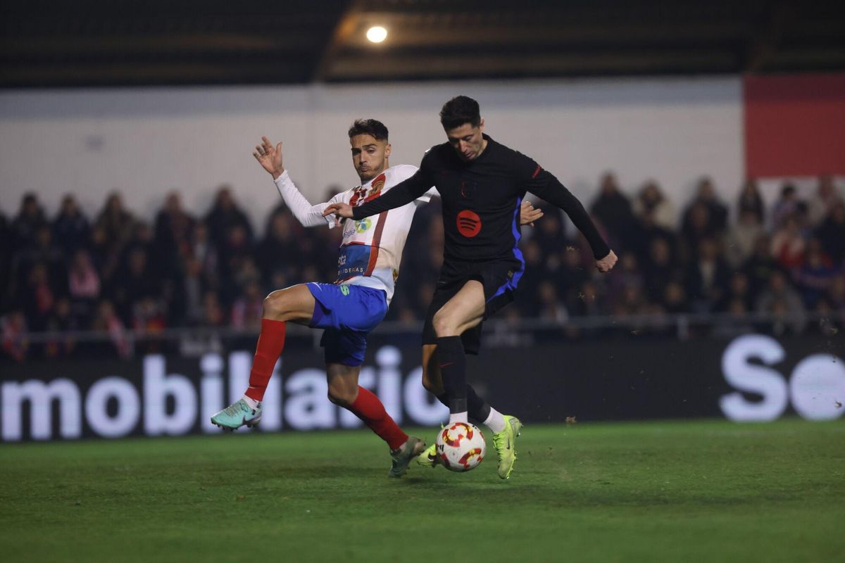 Isra García intenta arrebatarle el balón a Lewandoski en el Barbastro-Barça de Copa del Rey