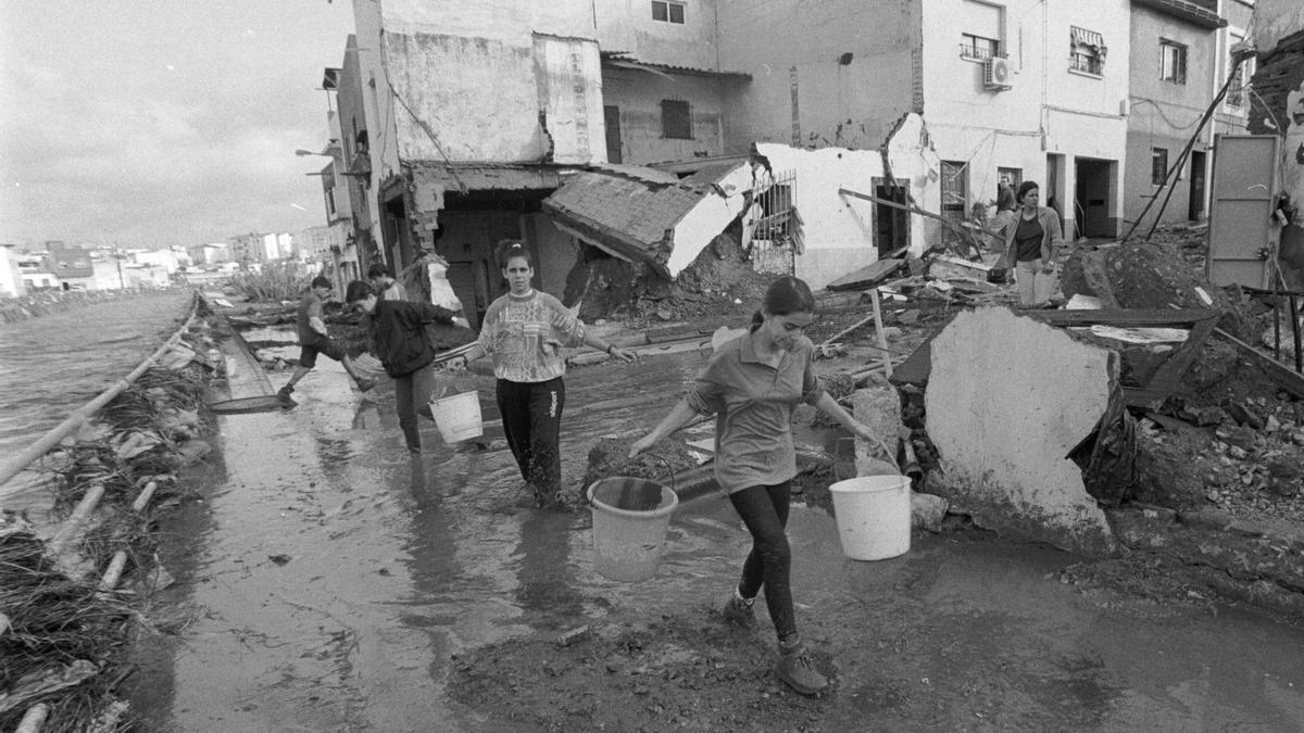 Dos niñas recogen lodo de sus casas, cercanas al arroyo, hace 25 años.