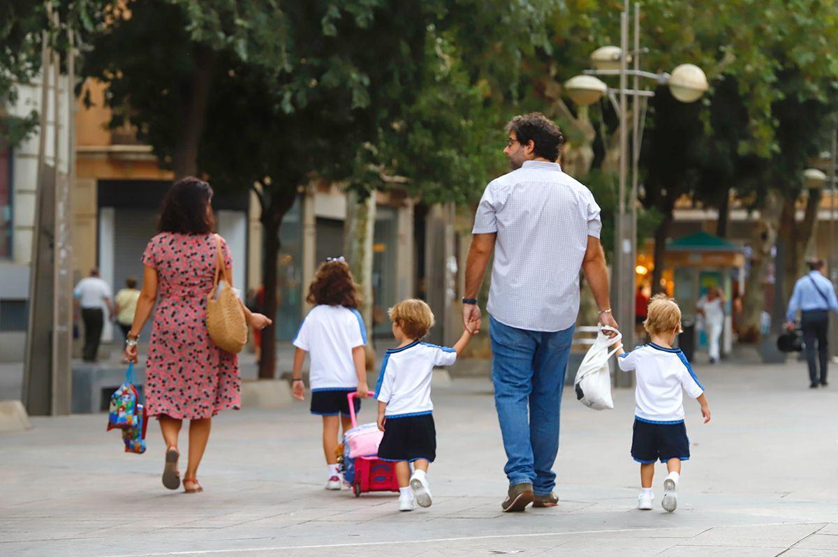 Un padre lleva a sus hijos al colegio en Córdoba.