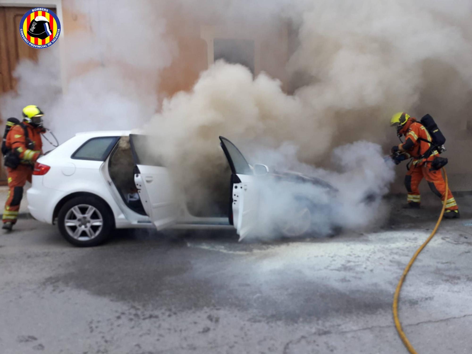 Los bomberos apagan un vehículo incendiado en plena calle en Carlet