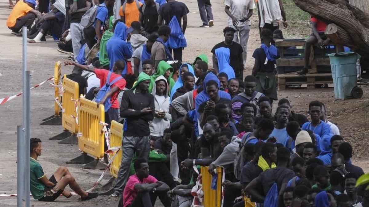 Decenas de inmigrantes hacen cola en el centro de acogida de Las Raíces, en La Laguna (Tenerife).