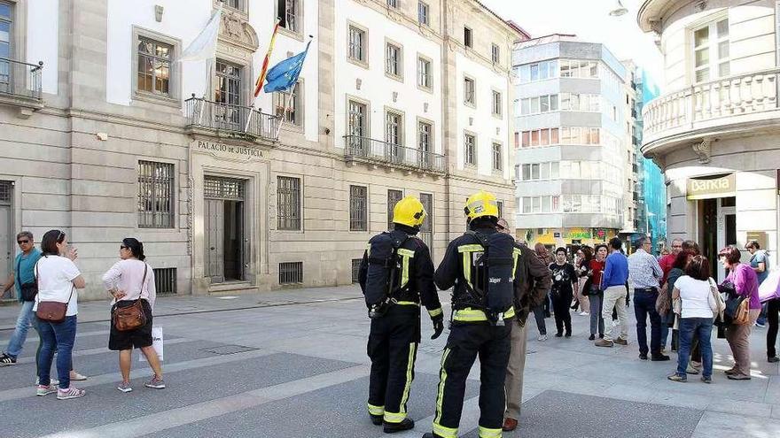 Los bomberos ante la Audiencia con buena parte de los funcionarios en el exterior del edificio. // R. V.