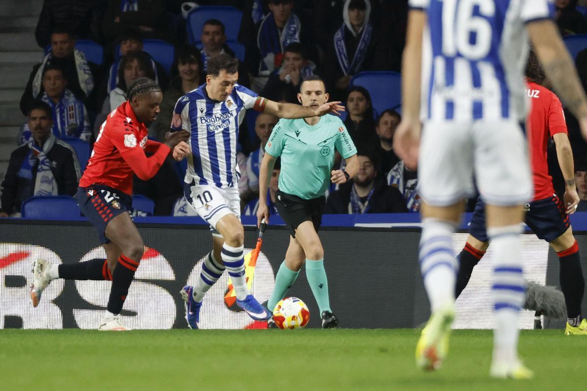 SAN SEBASTIÁN, 13/01/2026.- El delantero de la Real Sociedad, Mikel Oyarzabal (2i), intenta llevarse el balón ante el defensa camerunés de Osasuna, Enzo Boyomo, durante el encuentro correspondiente a los octavos de final de la Copa del Rey que disputan hoy martes en el estadio de Anoeta, en San Sebastián. EFE / Javier Etxezarreta