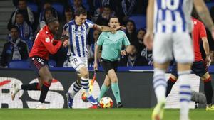 SAN SEBASTIÁN, 13/01/2026.- El delantero de la Real Sociedad, Mikel Oyarzabal (2i), intenta llevarse el balón ante el defensa camerunés de Osasuna, Enzo Boyomo, durante el encuentro correspondiente a los octavos de final de la Copa del Rey que disputan hoy martes en el estadio de Anoeta, en San Sebastián. EFE / Javier Etxezarreta