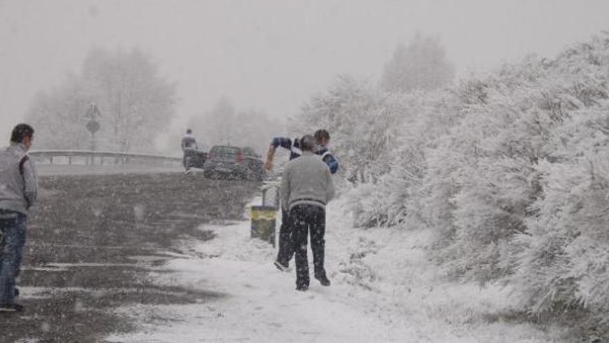 Varias personas se bajan de los coches en el alto de Padornelo para disfrutar de la nieve que ayer cubrió toda la zona alta de la comarca de Sanabria.