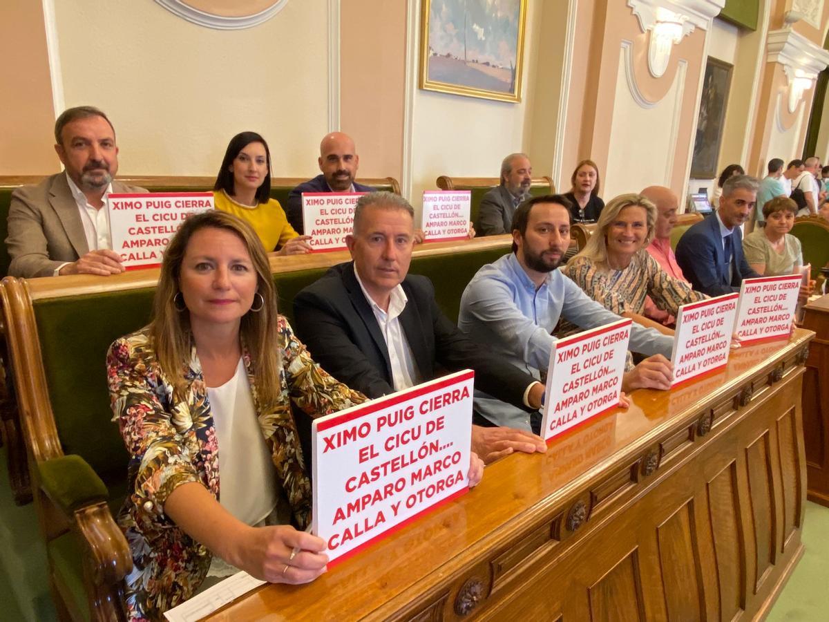 Los concejales del PP con el cartel sobre Puig, marco y el Cicu, en el pleno.