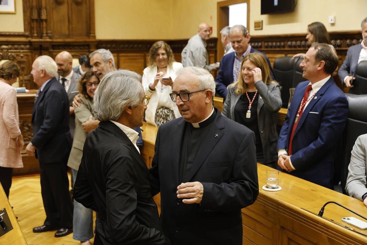 Miguel Marinero, amigo de Massiel, y el padre Arturo Muiño se saludan al final del Pleno