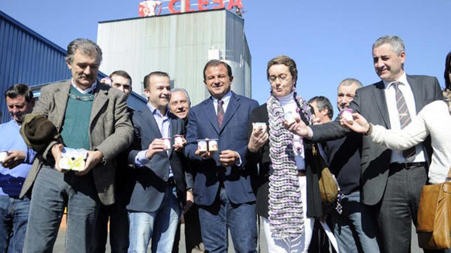 El conselleiro Javier Guerra sostiene los yogures de clesa junto a los trabajadores de la planta.