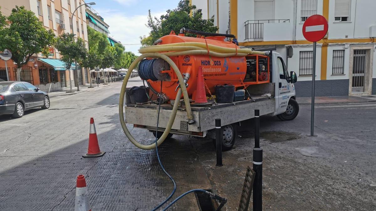 Un camión limpia un imbornal en la avenida de la Constitución de Montilla.