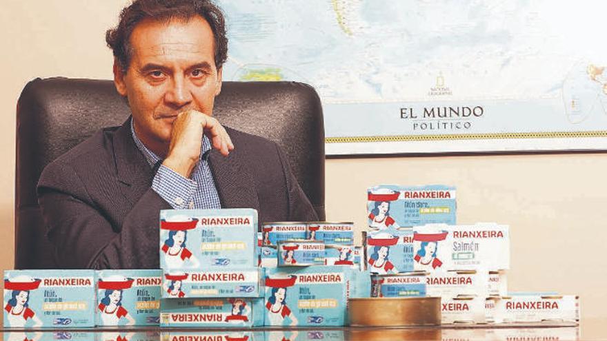 Jesús Alonso, en su despacho, junto a algunas de las latas de conserva de su fábrica.