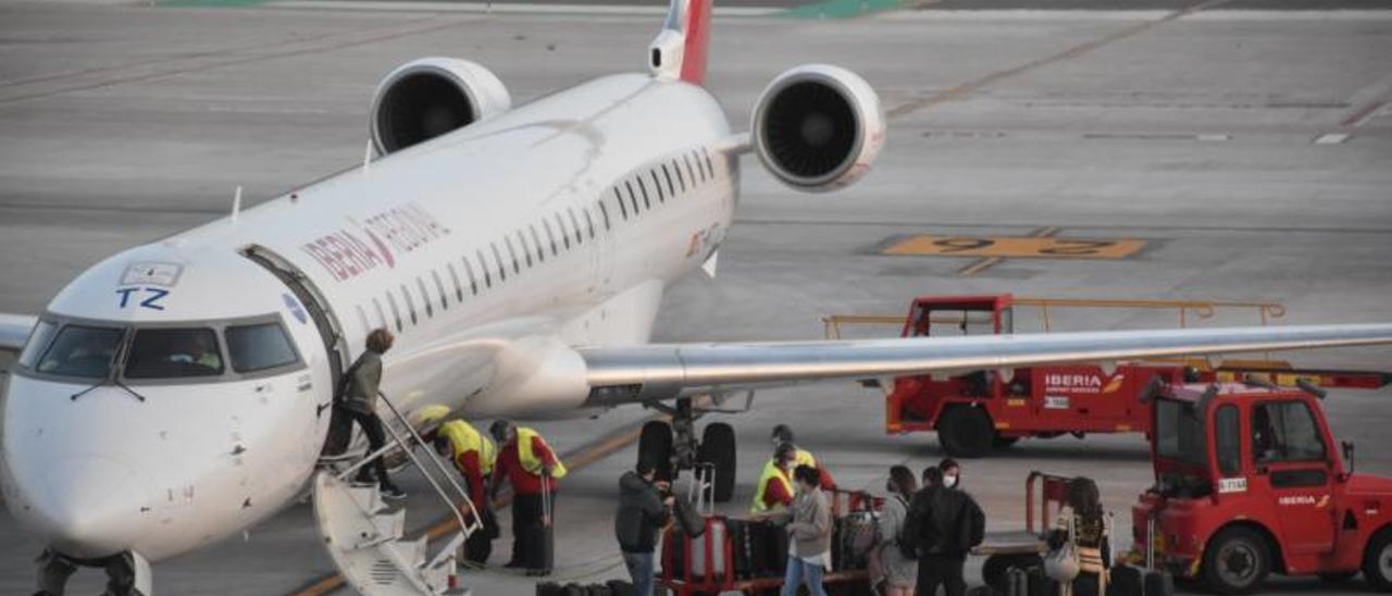 Pasajeros desembarcan de un avión en la plataforma de estacionamiento de Eivissa este año. | C.NAVARRO
