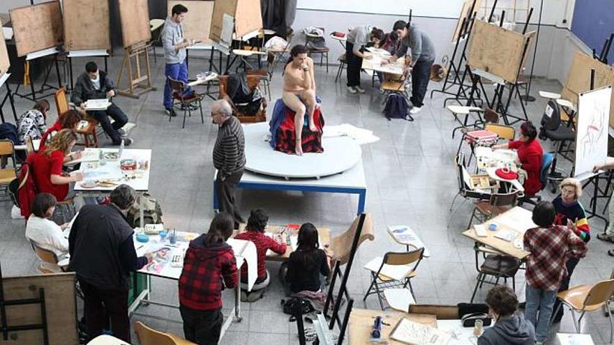 Estudiantes de la Facultad de Bellas Artes trabajan a partir de desnudos reales en su propia nave de dibujo, en dos imágenes tomadas este curso .