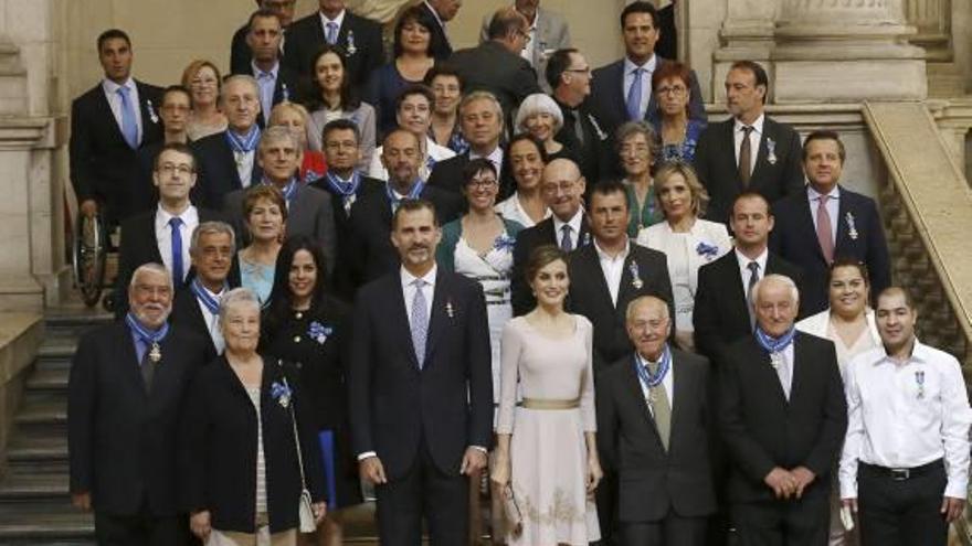 Arriba, Amelia Carreras con los Reyes; abajo, foto de grupo de los galardonados.