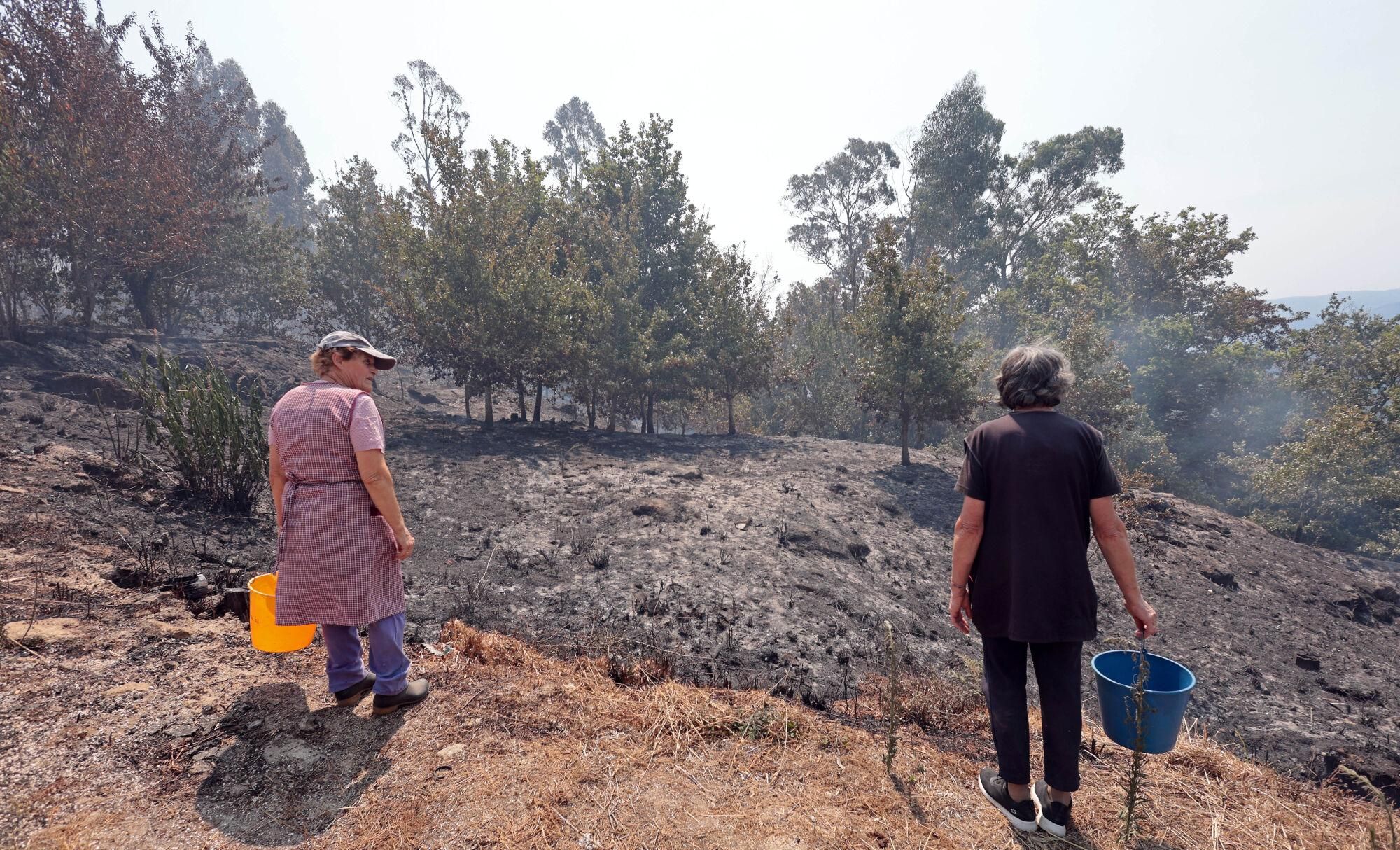 Imágenes del incendio en A Cañiza que obligó a confinar hasta siete núcleos de población en la parroquia de Valeixe.