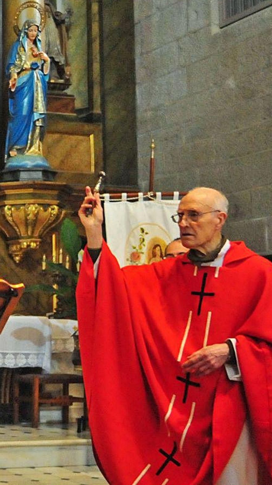 El párroco bendice las palmas dentro del templo.